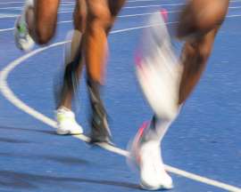 Blurred legs and feet of three elite African male runners on a track