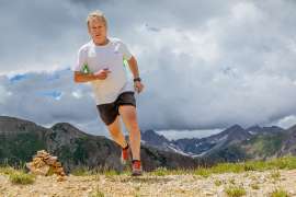 Sixty year old male trail runner cresting a 12,000 foot high alpine pass La Plata Mountains Colorado